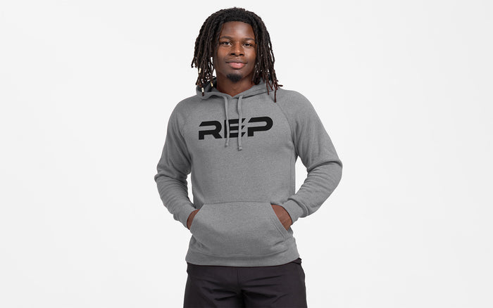The REP Fitness Unisex Daily Driver 2.0 Pull Over Hoodie in Heather Gunmetal/Black front, hands in pockets