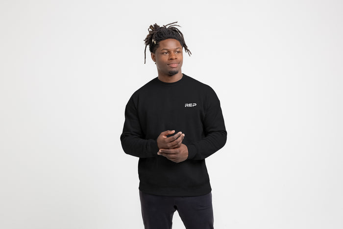 The REP Fitness Unisex REP® Crewneck Sweatshirt in Black/White front, hands clasped