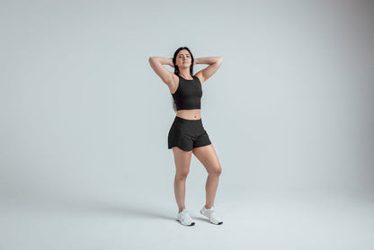 The REP Fitness Women's Artemis Shorts in Black front, hands behind head