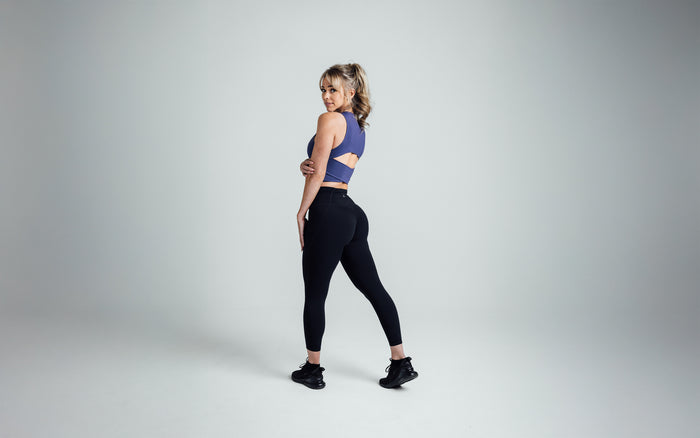 The REP Fitness Women's Rhea Cropped Tank Top in Dusk back, looking over shoulder