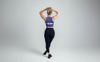 The REP Fitness Women's Rhea Cropped Tank Top in Dusk back, arms overhead