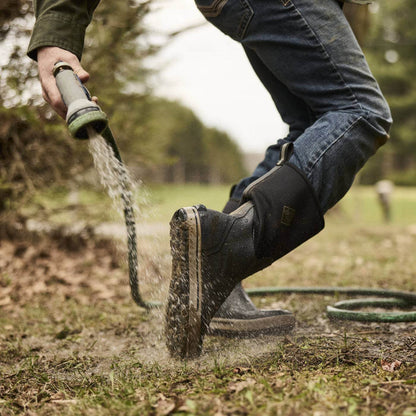 MXP12M00 Person rinsing off Xplorer 12" Men's Waterproof Outdoor Boots with hose showing the outsole.