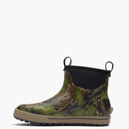 A single ankle-height rain boot with a green and brown leafy camouflage pattern, a black elastic side panel, and a beige outsole, shown against a plain white background.